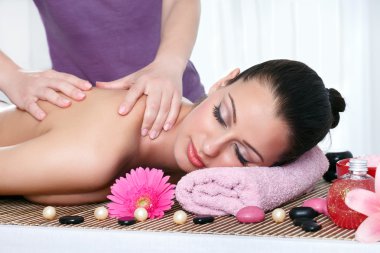 Woman in a day spa getting a deep tissue massage clipart