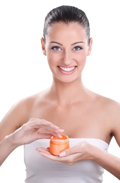 Mujer sonriente aplicándose crema en la cara —  Fotos de Stock