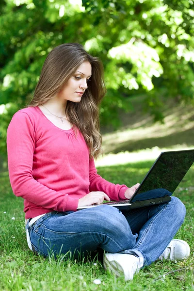Usando laptop no parque — Fotografia de Stock