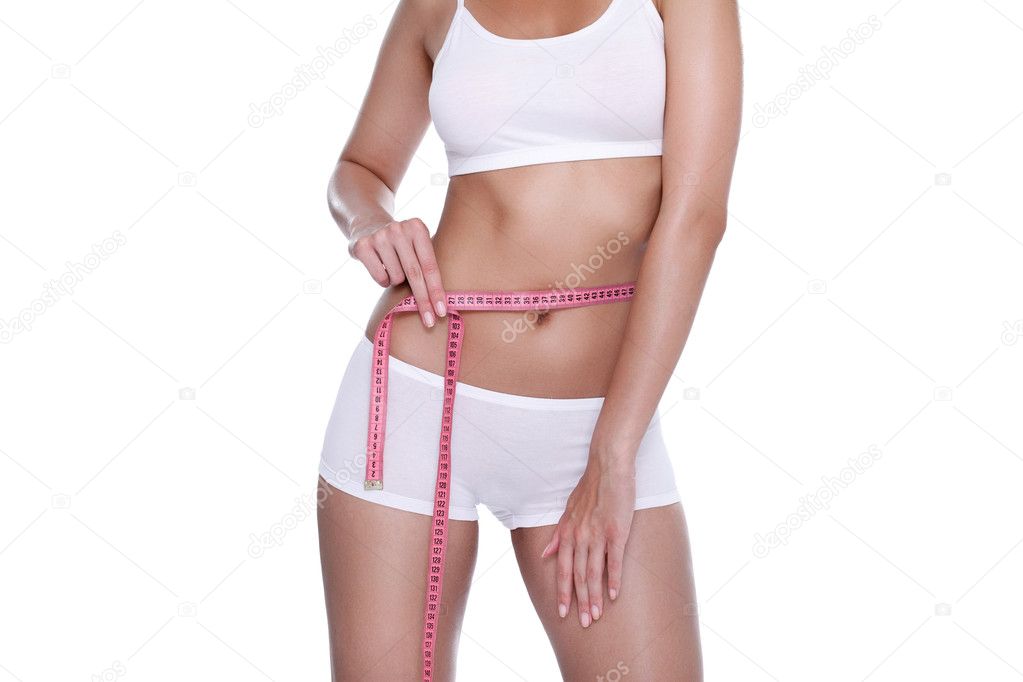 Fit and healthy young lady measuring her waist with a tape measure