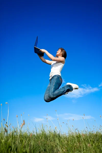 Girl jumping with laptop — Stock Photo, Image