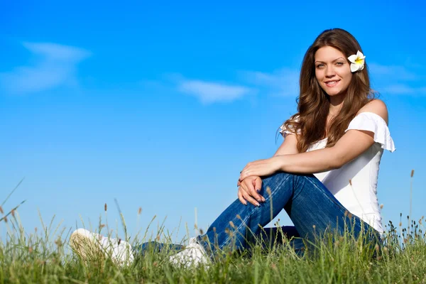 Krásná žena, sedící na trávě — Stock fotografie