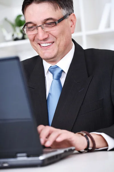 Udany biznes człowiek pracuje na stole z laptopa — Zdjęcie stockowe