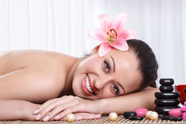 Mulher sorridente no salão de spa, massagem de pedra — Fotografia de Stock