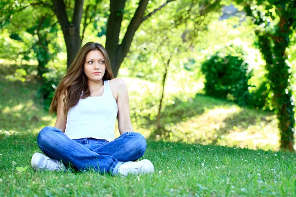 Jovem mulher relaxante na grama — Fotografia de Stock