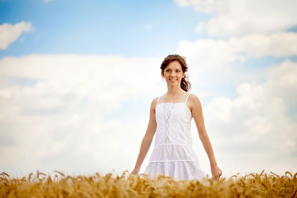 Mulher sorridente em vestido branco no campo — Fotografia de Stock