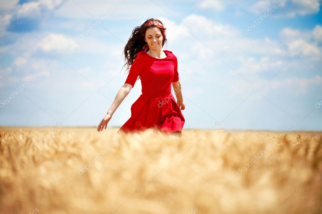 Romantic woman running across field