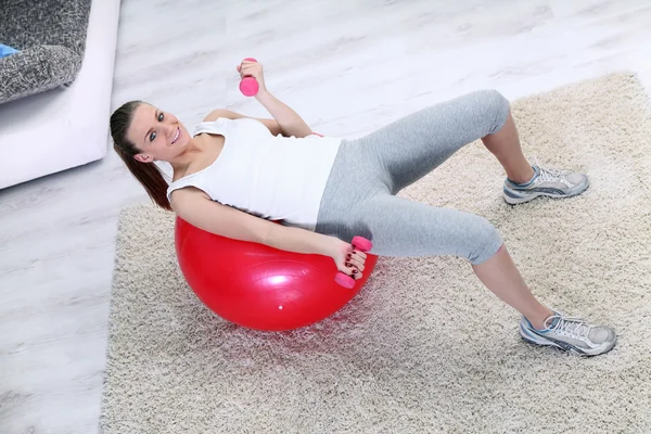 Mulher de exercício com pesos de levantamento na bola — Fotografia de Stock