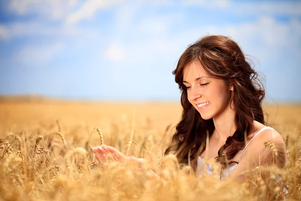 Усміхнена жінка в золотій пшениці — стокове фото