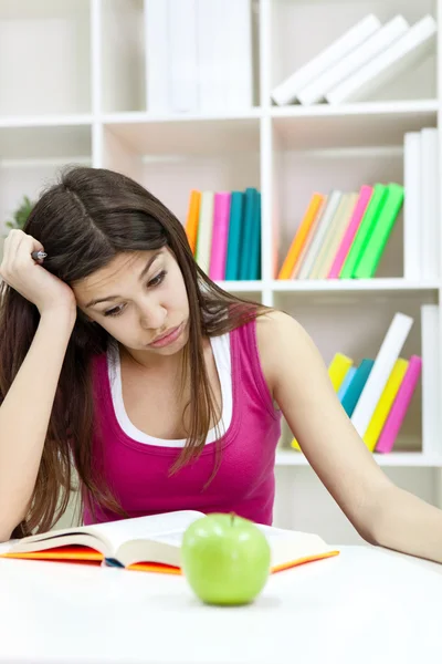 Dospívající dívka studuje na stole být unavený — Stock fotografie