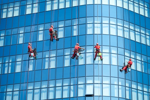 Arbetstagare tvätta fönster i kontorsbyggnaden — Stockfoto