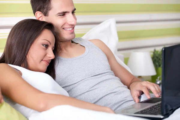 Par i säng med laptop — Stockfoto