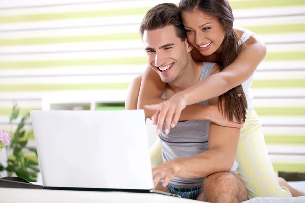 Ungt par embracing och ser laptop — Stockfoto