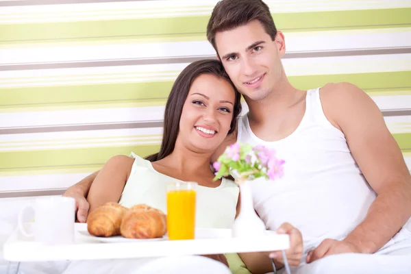 ベッドで朝食を楽しむカップル — ストック写真