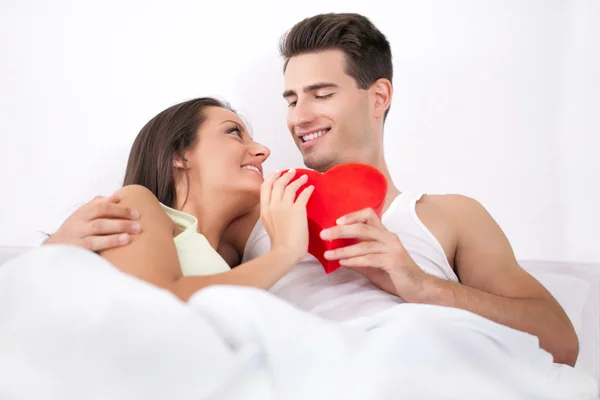 Couple lying in bed valentine heart — Stock Photo, Image