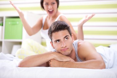 Couple having an argument in the bedroom clipart