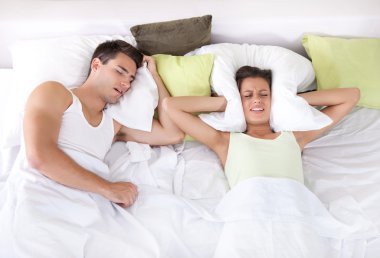 Upset woman in bed with her boyfriend snoring clipart