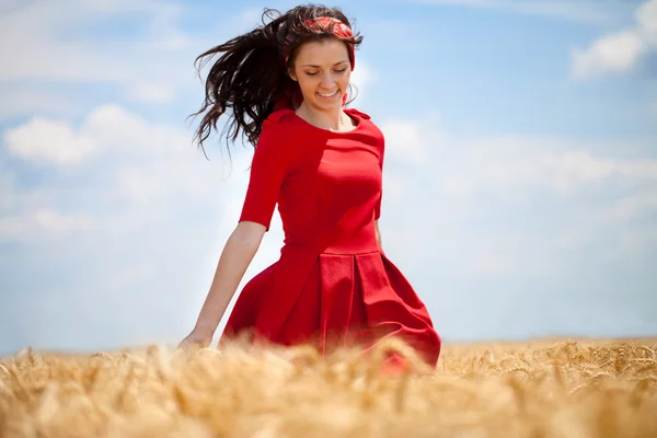 Woman running through a wheat field — Stock Photo, Image