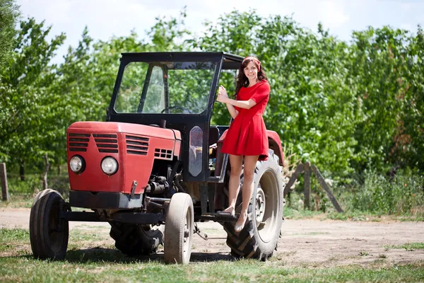 Деревенская девушка на тракторе — стоковое фото