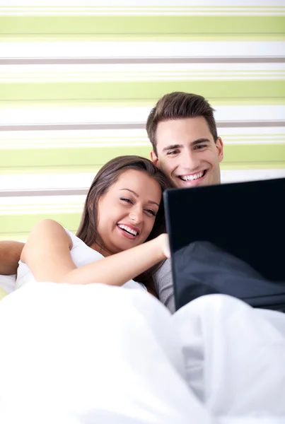 Ζευγάρι με το laptop στο κρεβάτι — Φωτογραφία Αρχείου