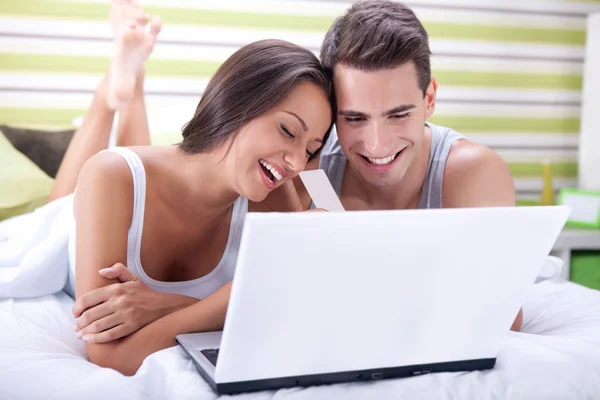 Paar im Bett kauft online mit Kreditkarte — Stockfoto