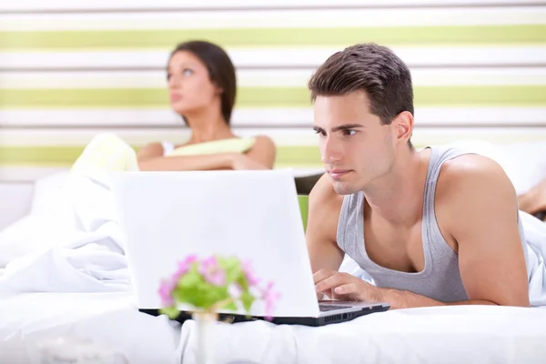Unhappy woman because his husband working in bed — Stock Photo, Image