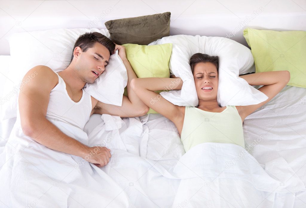 Upset woman in bed with her boyfriend snoring