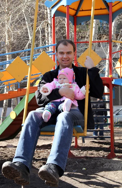Baba ve kızı bir salıncak erken bahar binmek