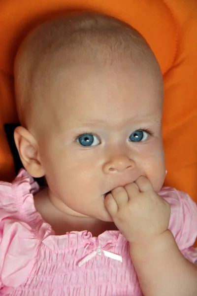 Portrait of cute baby girl sucking fist Stock Photo