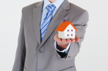 Businessman with a house clipart