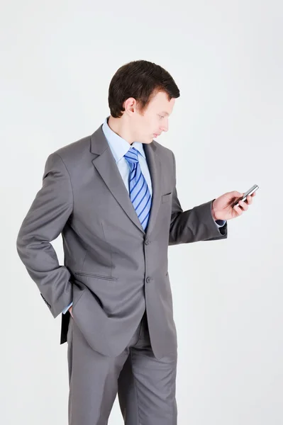 Młody biznesmen z telefonem komórkowym — Zdjęcie stockowe