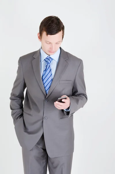 携帯電話を持つ若いビジネスマンは — ストック写真