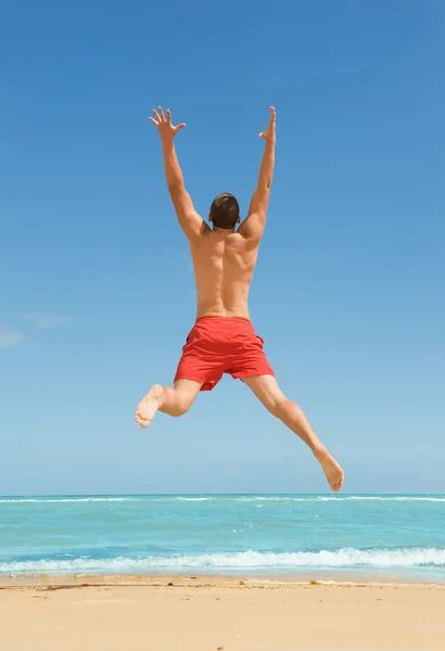 Чоловік стрибає на пляжі — стокове фото