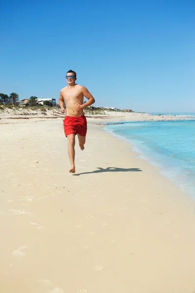 Człowiek biegnie wzdłuż wybrzeża — Zdjęcie stockowe