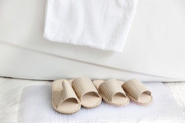 Slippers and bath towel by the bathtub clipart