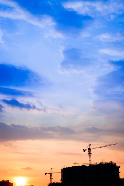 Industriebaukräne und Gebäudesilhouetten bei Sonnenaufgang — Stockfoto