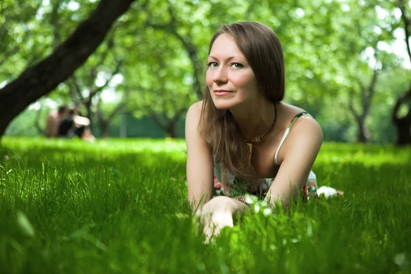 Beautiful woman is lying on the grass — Stock Photo, Image