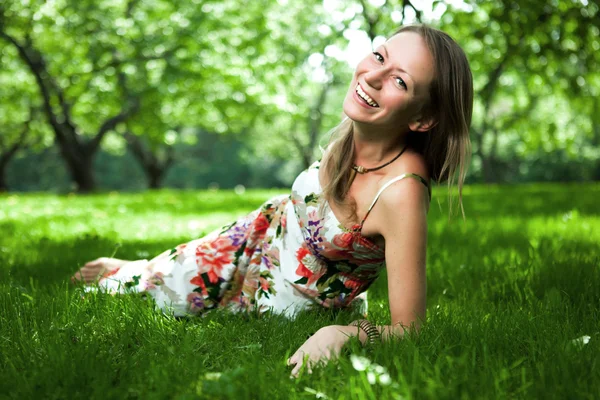Beautiful woman is lying on the grass — Stock Photo, Image