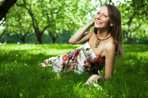 Piękna kobieta jest leżąc na trawie — Zdjęcie stockowe