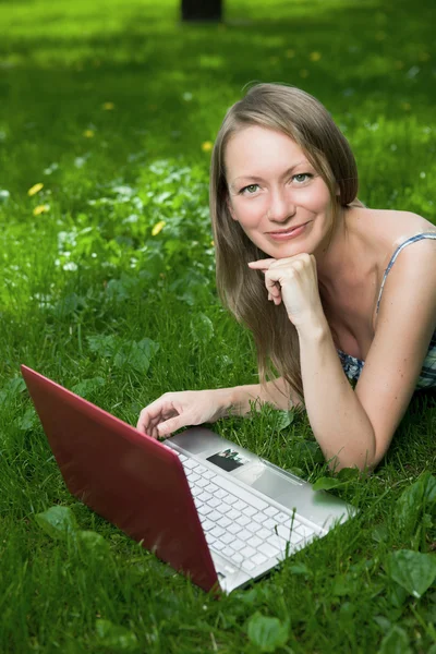Menina atraente com um laptop no parque — Fotografia de Stock