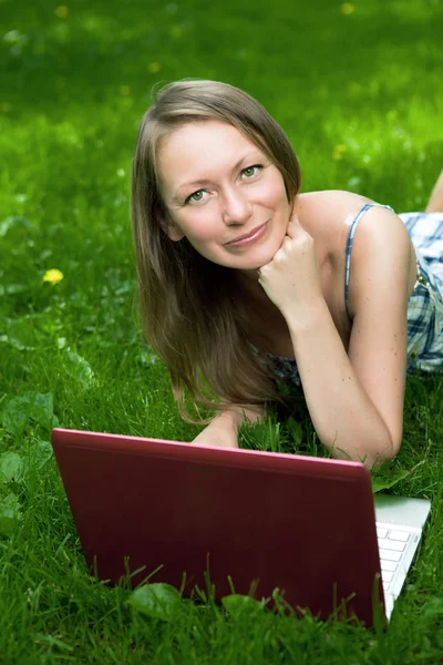 Aantrekkelijk meisje met een laptop in het park — Stockfoto