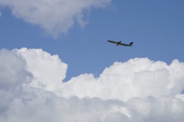 Mavi gökyüzü ile bulutların üzerinde uçak