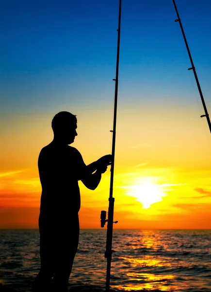Fiskare pojke fiske i vacker solnedgång — Stockfoto