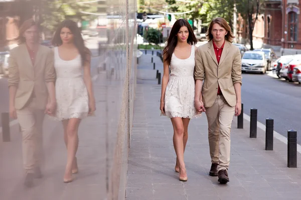 Молодая пара, идущая по улице — стоковое фото