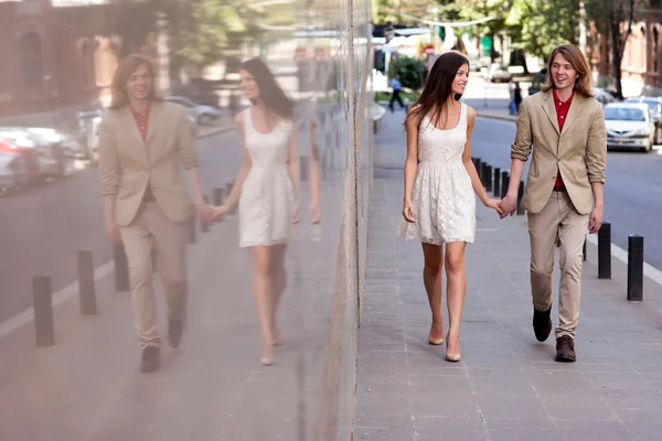 Jeune couple marchant dans la rue — Photo