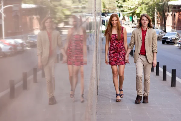 Молодая пара, идущая по улице — стоковое фото