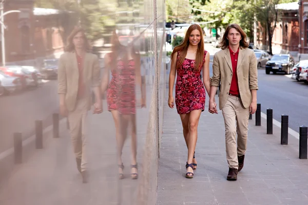 Jeune couple marchant dans la rue — Photo