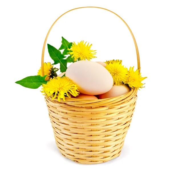 Ovos em uma cesta com dentes-de-leão — Fotografia de Stock