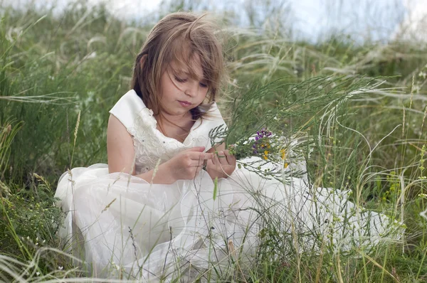 在与外地花卉草坪上童话般漂亮的小女孩 — 图库照片