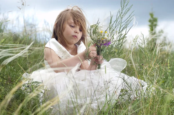 Bajkowy śliczną dziewczynkę na trawnik z kwiat pole — Zdjęcie stockowe